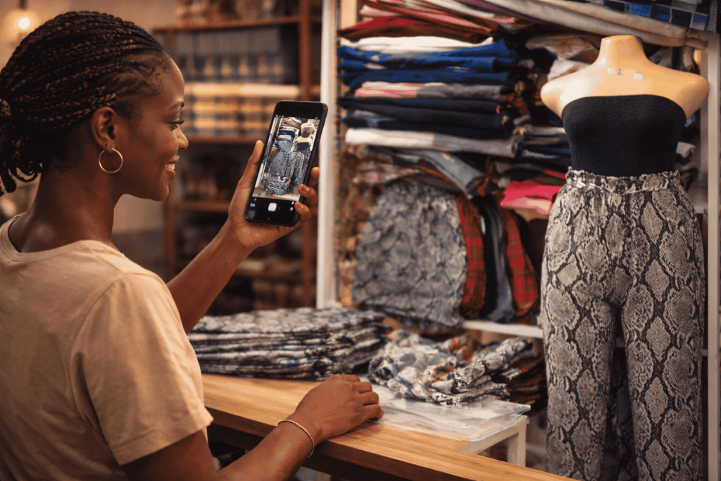 African entrepreneur selling products through social media and messaging platforms on a smartphone